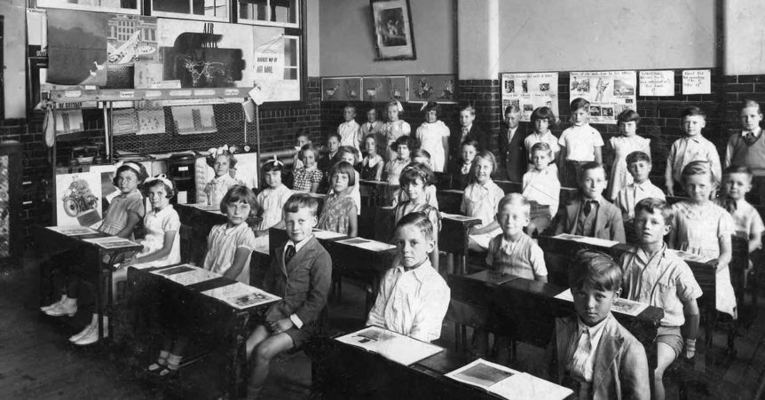 black and white photo of elementary school children in a classroom